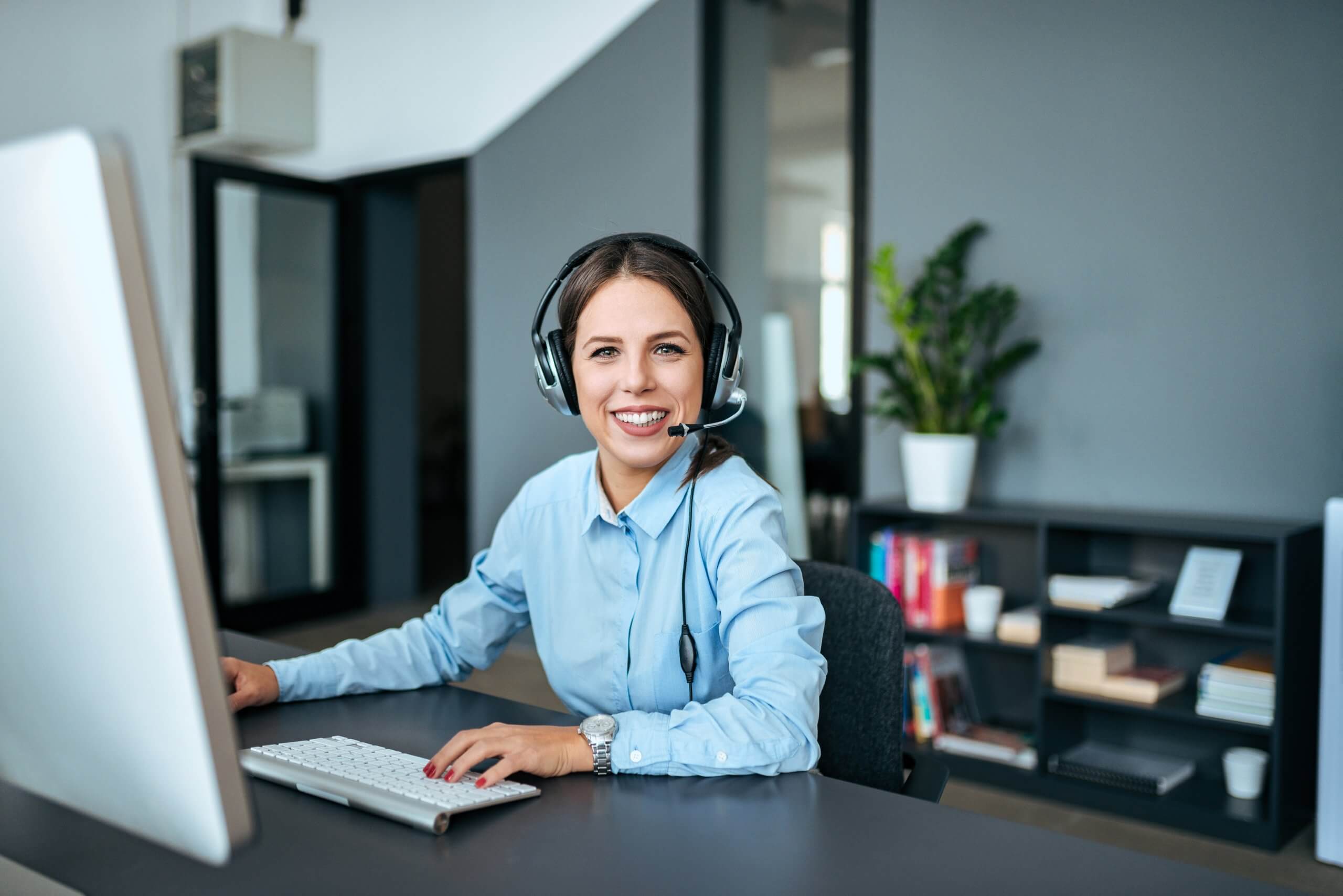 Portrait of a young female support center agent sitting ...