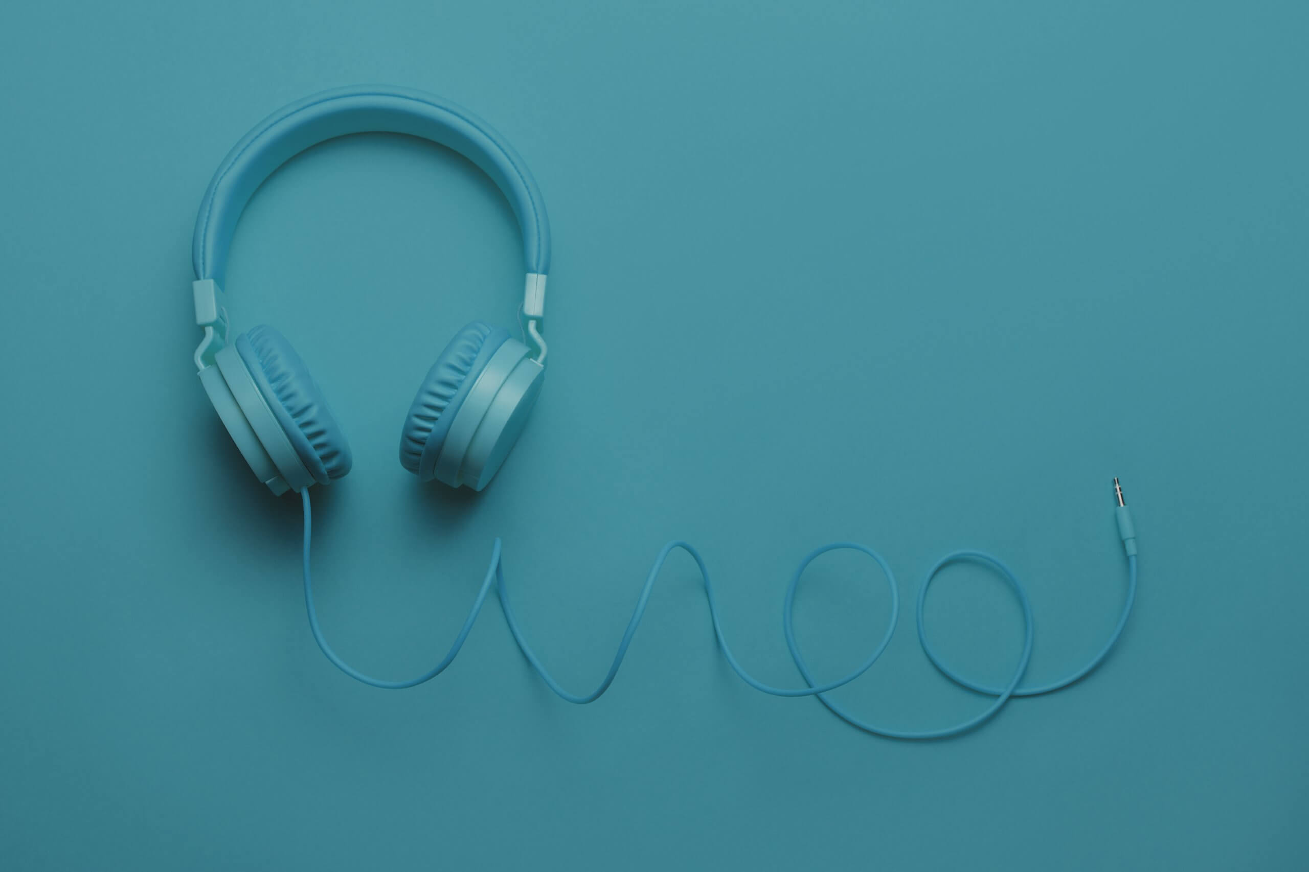Blue headphones on blue background. Music concept ContactCenter4ALL